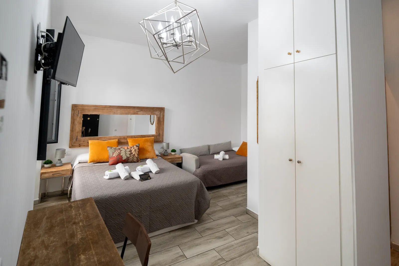 Blick in das Dreibettzimmer mit Doppelbett, Schlafsofa, Kleiderschrank und Schreibtisch